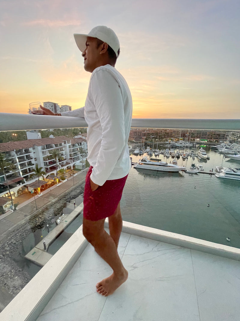 Man standing on balcony with sunset in Copper Bottom Swim trunks